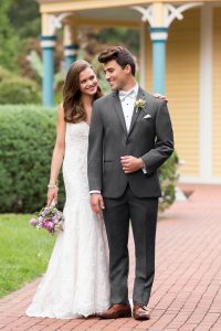 Newlywed couple walking outdoors at their venue while bride and groom look lovingly at each other