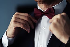 Grooms suit close up detail, groom wearing black suit in the wedding day with a flower attached