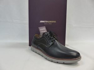 Shiny black dress shoe in front of shoe box that says “Johnston & Murphy”