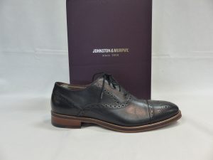 Black dress shoes sitting on top of box that says “Johnston & Murphy”