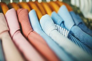Assortment of men’s shirts on wooden hangers